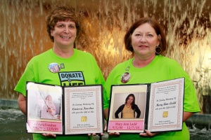 Cathy and Vickie with photos of daughters